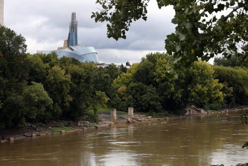 Stdup . Forks  River Walk is just barely flooded again after recent rains make their way into the city of Winnipeg along the swollen  Assiniboine River . CMHR's in background as seen fom what the city likes to call the Midland Bridge   SEPT  4 2014 / KEN GIGLIOTTI / WINNIPEG FREE PRESS