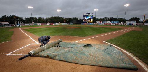 PLAY BALL, ground crews roll up protective tarps at Shaw Park to put the Goldeyes and Saltdogs on a slightly damp field in the second playoff match this week between the two rivals.  September 4, 2014 - (Phil Hossack / Winnipeg Free Press)