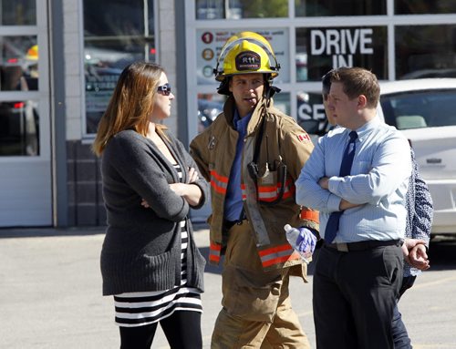 Winnipeg Fire Fighter with people outside Pembina Dodge Chrysler, crews were called to the dealership about 11:30 a.m. after reports of a package containing a powder had been opened by a staff member. Geoff Kirbyson story  Wayne Glowacki/Winnipeg Free Press Sept.5 2014