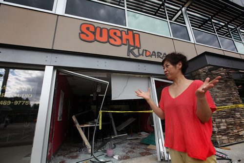 Kyungjae Lee, describes how she was setting a table in her restaurant on Academy seconds before a car came smashing through the window Saturday afternoon.  Fortunately no one was injured in the accident.  See Mary Agnes Story.   Sept 04.  2014 Ruth Bonneville / Winnipeg Free Press   Ruth Bonnevilles