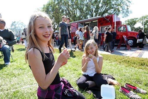 Ten-year-old Jessica Smith eats samosa's with her younger sister Lauren - 8yrs, while visiting ManyFest with their parents Saturday afternoon.  

Sept 04.  2014 Ruth Bonneville / Winnipeg Free Press  
Ruth Bonnevilles  

