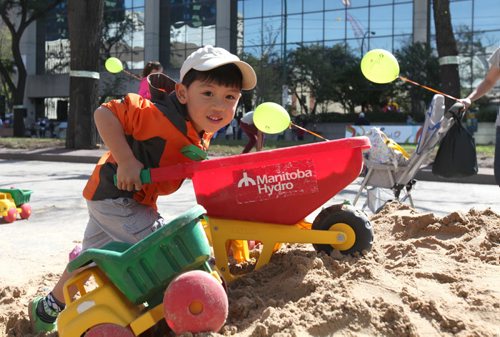 Four-year-old Darren Tang plays in mounds of sand set up along Broadway in the kids play zone at ManyFest Saturday afternoon.    Sept 04.  2014 Ruth Bonneville / Winnipeg Free Press   Ruth Bonnevilles