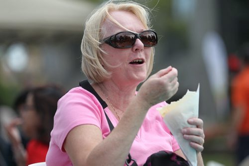 Christine Baumer enjoys a crepe filled with fruit and cream cheese on Broadway during ManyFest Saturday afternoon.    Sept 04.  2014 Ruth Bonneville / Winnipeg Free Press   Ruth Bonnevilles