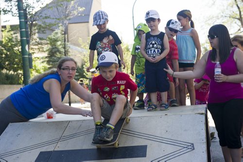 140907 Winnipeg - DAVID LIPNOWSKI / WINNIPEG FREE PRESS  Lindsay Cushnie pushes her son Ryan (5) down a ramp on a skateboard during Manyfest Sunday afternoon.