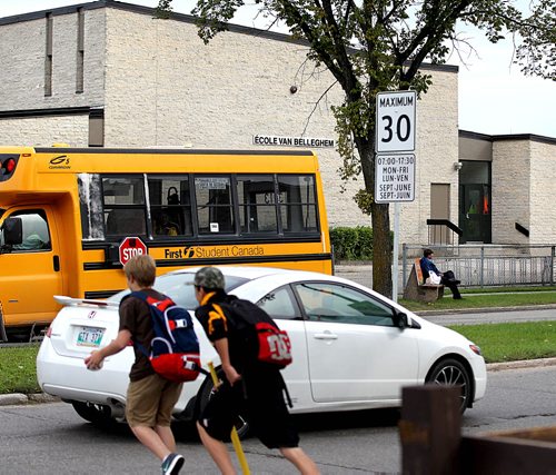 A group of boys run across Lakewood Blvd to catch their bus near Ecole Van Belleghem School Tuesday.  For story on school zone traffic signs, notifying drivers of speed limit of 30km during school hours.   See story on new school zone speed limits.  Sept 09.  2014 Ruth Bonneville / Winnipeg Free Press   Ruth Bonnevilles