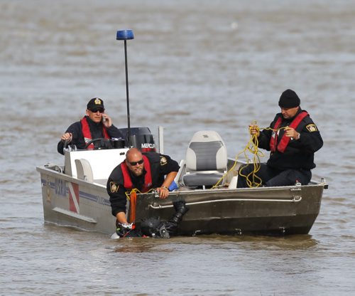 LOCAL - Winnipeg Police Services Underwater Search and Recovery Unit work on pulling up something from the Red River just downstream from the Alexander Street Docks. BORIS MINKEVICH / WINNIPEG FREE PRESS  Sept. 9, 2014