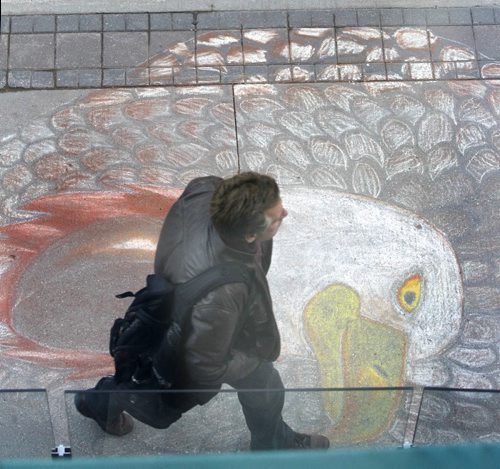 Pedestrians walk past a beautifully drawn eagle on the sidewalk along Portage Ave. by the MTS Centre Wednesday morning. The Aboriginal Peoples Choice Music Awards  will be held at the MTS Sept12 part of the 2014 Manito Ahbee Festival that  runs September 10 - 14. Wayne Glowacki/Winnipeg Free Press Sept.10 2014