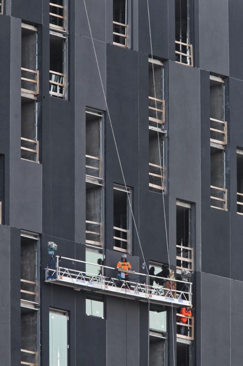 Crews install windows in the new hotel being built across the street from the MTS Centre Wednesday morning.  140910 September 10, 2014 Mike Deal / Winnipeg Free Press