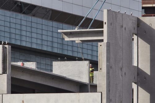 Crews install large concrete slabs for the new parkade being built behind the new hotel across the street from the MTS Centre Wednesday morning.  140910 September 10, 2014 Mike Deal / Winnipeg Free Press