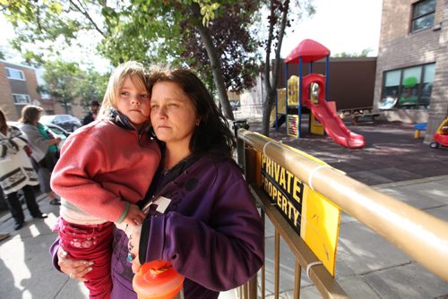 Foster mom, Chanda Bergson holds four-year-old Mya Gibson (Mya is spelt with a y) outside Family Community Centre Daycare on Sargent Ave. that has had their outdoor play area closed numerous times in past few days due to falling rocks a debris from roofers  working on the building's rooftop.  Mya attends the daycare with Bergson's foster children.   See Ashley's story.  Sept 10.  2014 Ruth Bonneville / Winnipeg Free Press   Ruth Bonnevilles