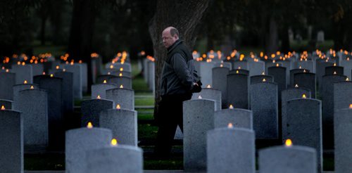 Candles Glow, row on row....David Bartlett walks between rows of veteran graves at Brookside Cemetery Wednesday evening at the Candle Light Vigil held to mark the Anniversary of the start of WW2. See release. September 10, 2014 - (Phil Hossack / Winnipeg Free Press)