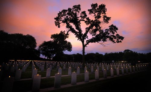 Candles Glow, row on row....An ancient Oak holds vigil over rows of veteran graves each lit with a candle at Brookside Cemetery Wednesday evening at a Vigil held to mark the Anniversary of the start of WW2. See release. September 10, 2014 - (Phil Hossack / Winnipeg Free Press)