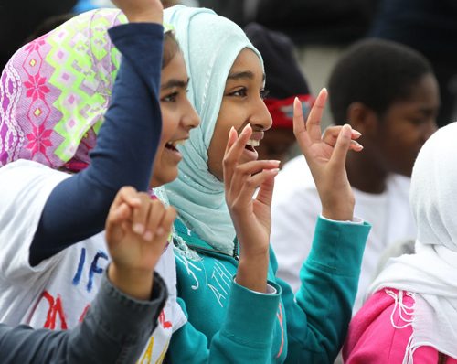 Sumha Ali (left) and Ahlam Semir from Al Hijra Isamic School make peace signs at Scotia Bank stage next to The Canadian Museum for Human Rights Thursday morning along with hundreds of Winnipeg school students for the annual Peace Days at the Forks.  The students took part in a walk and other activities promoting peace leading up to the grand opening of the iconic national museum. Standup  Sept 11.  2014 Ruth Bonneville / Winnipeg Free Press