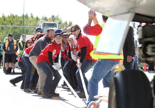 United Way representatives pull a plane along the tarmac as they compete in the 11th annual United Way Plane Pull, a fundraising event to raise funds for the charity.  Standup Sept 12,  2014 Ruth Bonneville / Winnipeg Free Press