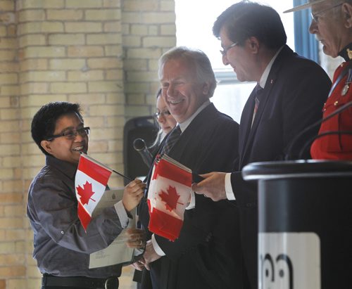 From left, new Canadian Maria Christina Cruz originally from the Philippines,  Dwight MacAulay, Manitoba's chief of protocol, was the presiding officer with special guest Parliamentary Secretary Costas Menegakis  welcomed the 78 people that became Canadas newest citizens at a citizenship ceremony at the Manitoba Childrens Museum Friday.    see release Wayne Glowacki/Winnipeg Free Press Sept.12 2014