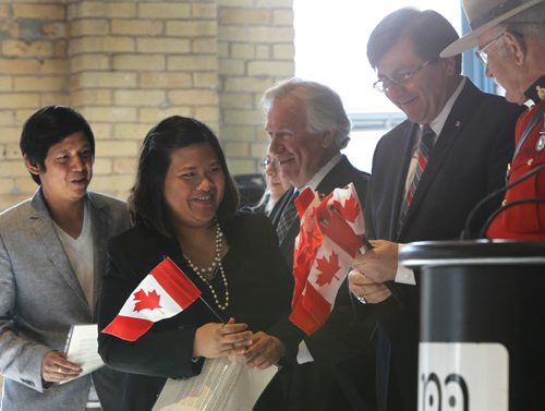 From left, Mark Delmo and his wife Vicel Karunungan originally from the Philippines were among the 78 people that became Canadas newest citizens at a citizenship ceremony in the Manitoba Childrens Museum Friday.  Dwight MacAulay, Manitoba's chief of protocol, was the presiding officer with special guest Parliamentary Secretary Costas Menegakis welcomed the new Canadians.  see release Wayne Glowacki/Winnipeg Free Press Sept.12 2014