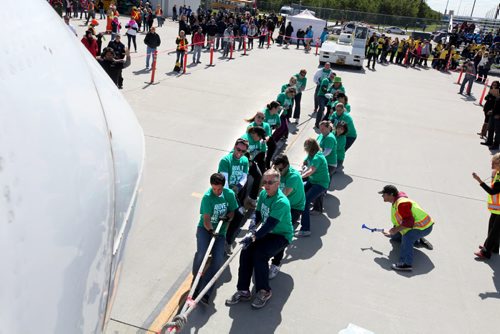 Manulife representatives pull a plane along the tarmac as they compete in the 11th annual United Way Plane Pull, a fundraising event to raise funds for the charity.  Standup Sept 12,  2014 Ruth Bonneville / Winnipeg Free Press