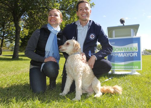 Brian Bowman, his wife Tracy and his dog Indiana at a press announcement in the park on the Red River across the street from the new Human Rights Museum. BORIS MINKEVICH / WINNIPEG FREE PRESS  Sept. 12, 2014