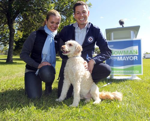 Brian Bowman, his wife Tracy and his dog Indiana at a press announcement in the park on the Red River across the street from the new Human Rights Museum. BORIS MINKEVICH / WINNIPEG FREE PRESS  Sept. 12, 2014