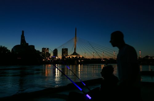 People fish along the Red River, with downtown Winnipeg, and the Canadian Museum for Human Rights and Esplanade Riel in the background. City Beautiful 140901 - Monday, September 01, 2014 - (Melissa Tait / Winnipeg Free Press)