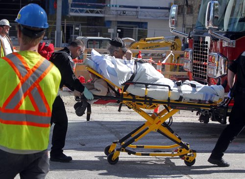 An explosion on the construction site where the new Glass House project sent one worker to hospital with non life threatening injuries. Here fire paramedics with victim. BORIS MINKEVICH / WINNIPEG FREE PRESS  Sept. 15, 2014