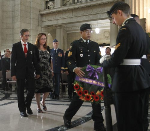 Sgt. Tony Vu carries the wreath on behalf of the Families of the Fallen to be placed by Keith and Penny Greenfield who lost their son Sean David Greenfield,25, when the armoured vehicle he was inside in 2009 struck a roadside bomb in the volatile Zhari district.  The ceremony was held Tuesday to open the Afghanistan Memorial Vigil  at the Manitoba Legislative Building. The Vigil is built from the recovered memorial plaques from Kandahar Air Field cenotaph, the Vigil display focuses on fallen Canadians, including the 158 soldiers, a Canadian diplomat, contractor, journalist as well as 40 United States Armed Forces personnel attached to the Canadian Forces.Larry Kusch story Wayne Glowacki/Winnipeg Free Press Sept.16  2014