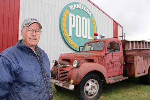 Albert Thompson's eclectic museum collection is going up for auction next month in Ste. Rose. It includes antique vehicles and farm equipment, as well as his own inventions. 049 - Albert Thompson in front of a former Manitoba Pool Elevators sign, and Ste. Rose du Lac's first fire truck, a 1948 Dodge.  BILL REDEKOP/WINNIPEG FREE PRESS Sept 16,2014
