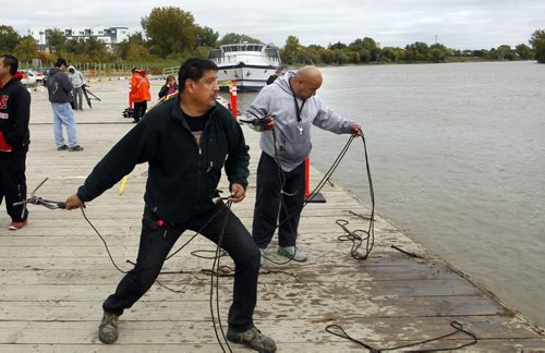 At left, Darryl Contois and Calvin Alexander were tossing grappling hooks off of the Alexander Docks into the Red River Wednesday in the search for missing women. see story Wayne Glowacki/Winnipeg Free Press Sept.17  2014