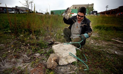A volunteer who drove "in from the east" and didn't want to give his name  fashions a grappling hook out of re-inforcing bar Wednesday along the Red River near the Alexander Docks. See Ashley Prest's story. September 17, 2014 - (Phil Hossack / Winnipeg Free Press)