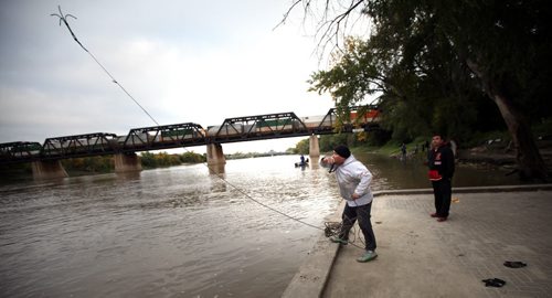 Volunteer Calvin Alexander hurls a home made grappling hook into the Red River Wednesday as a search for Missing and Murdered aborigional women got underway in Winnipeg. See Ashley Prest story. (Phil Hossack / Winnipeg Free Press)