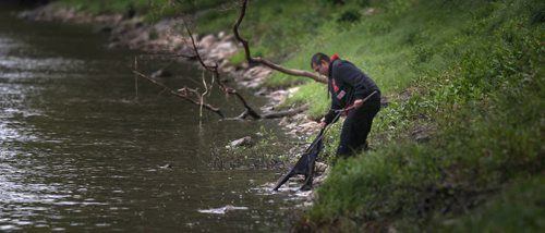 A volunteer pulls discarded clothing from the Red River Wednesday as a search for Missing and Murdered aborigional women got underway in Winnipeg. See Ashley Prest story. (Phil Hossack / Winnipeg Free Press)