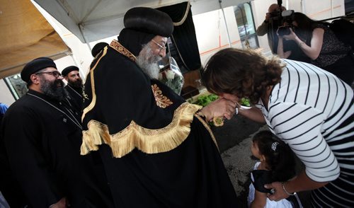 Slipping in under the radar of the Human RIghts Museum opening, Coptic Orthodox Pope Tawadros II stopped in Winnipeg Friday to lay a symbolic cornerstone of a new Coptic Cathedral to be built on Chevrier ave. A devout follower kisses his hand in the walk about at their current church on Chevrier. See Suderman's story / Release. September 19, 2015 - (Phil Hossack / Winnipeg Free Press)