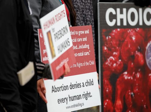 A small group of young,disarming pro life protestors gather outside the CMHR holding signs for Human Rights for the unborn child Saturday while hundreds of people make their way into the CMHR for a free tour of the first 4 installations.   Sept 20,  2014 Ruth Bonneville / Winnipeg Free Press