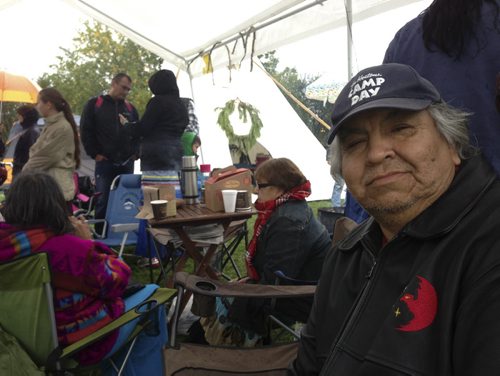 Carol Sanders / Winnipeg Free Press 
Pic of Jackson Osborne under the First Nations demonstrators' canopy where people sought shelter from Saturday's downpour near the Canadian Museum ofor Human Rights. For Sanders sidebar. Winnipeg Free Press. Sept. 20, 2014