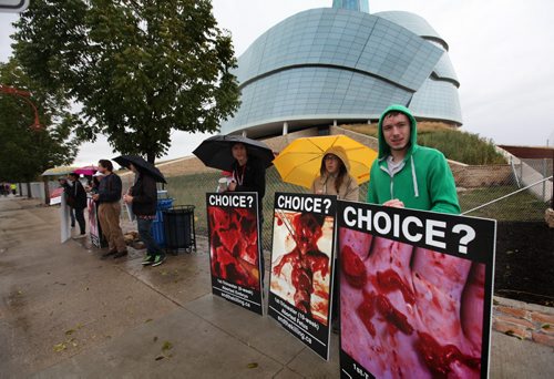 A small group of young, pro life protestors gather outside the CMHR holding signs for Human Rights for the unborn child Saturday while hundreds of people make their way into the CMHR for a free tour of the first 4 installations.   Sept 20,  2014 Ruth Bonneville / Winnipeg Free Press