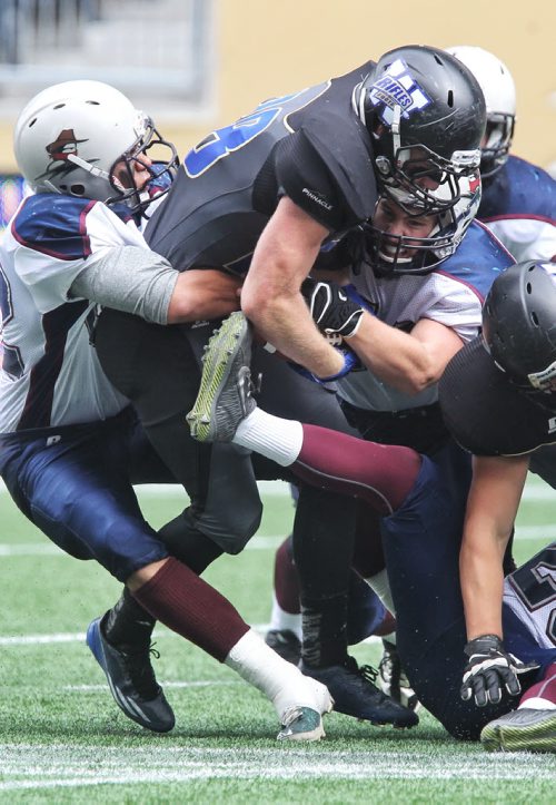 Winnipeg Rifles play the Regina Thunder at the Investors Group Field Sunday afternoon. Winnipeg Rifles' Logan Thacker (38) is pulled down by Regina Thunder players in the second quarter. 140921 - Sunday, September 21, 2014 -  (MIKE DEAL / WINNIPEG FREE PRESS)