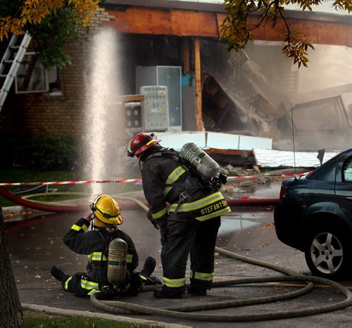 City firefighters battle a blaze at 27 Apple Lane after an explosion sent one man to hospital in critical condition. The entire north wall was blown out as seen behind the firefighters. See Ashley Prest story. September 23, 2014 - (Phil Hossack / Winnipeg Free Press)