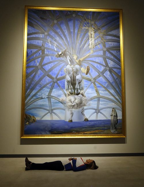 STDUP WAG . A Dali Moment , Alix Cameron demonstrates the recommended way to view the 4 m. high  painting  Santiago El Grande in the background .Most art galleries do not have doors big enough to bring this art work into the gallery .  The work of Salvador Dali  will  be on display at the Wag , two shows have been combined , the Dali UP Close and Masterworks from the Beaverbrook Art  Gallery  opening Sept. 27 SEPT  24 2014 / KEN GIGLIOTTI / WINNIPEG FREE PRESS