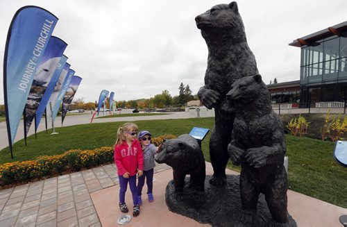 STDUP   visiting from Hamiota left Lauren age 5 with her sister Lucy Soutar age 3  view the new statue Mother Polar Bear and Cubs , dedicated  by the Assiniboine Park Conservancy to Unveil Sculpture at Assiniboine Park Zoo Entrance Winnipeg, September 24, 2014 Äì This morning, the Assiniboine Park Conservancy (APC) will unveil an original sculpture by Manitoba artist Peter Sawatzky outside the entrance to Assiniboine Park Zoo. The sculpture is a gift from an early leadership donor to the Imagine a Place Campaign who is also a founding member of the APC Board of Directors. SEPT  24 2014 / KEN GIGLIOTTI / WINNIPEG FREE PRESS
