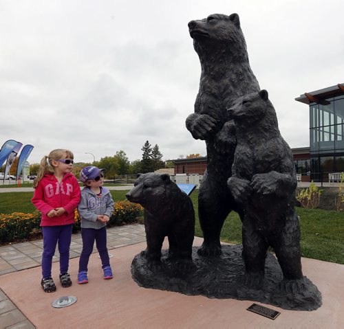 Stdup My What Big Eyes You Have -STDUP   visiting from Hamiota left Lauren age 5 with her sister Lucy Soutar age 3  view the new statue Mother Polar Bear and Cubs , dedicated  by the Assiniboine Park Conservancy to Unveil Sculpture at Assiniboine Park Zoo Entrance Winnipeg, September 24, 2014 Äì This morning, the Assiniboine Park Conservancy (APC) will unveil an original sculpture by Manitoba artist Peter Sawatzky outside the entrance to Assiniboine Park Zoo. The sculpture is a gift from an early leadership donor to the Imagine a Place Campaign who is also a founding member of the APC Board of Directors. SEPT  24 2014 / KEN GIGLIOTTI / WINNIPEG FREE PRESS