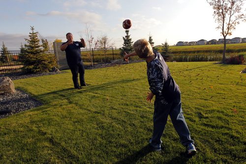 49.8 FEATURE - Wade Miller. Wade with son Branson Miller,8, chuck the football around in the back yard of their home in south Winnipeg.  BORIS MINKEVICH / WINNIPEG FREE PRESS  Sept. 24, 2014