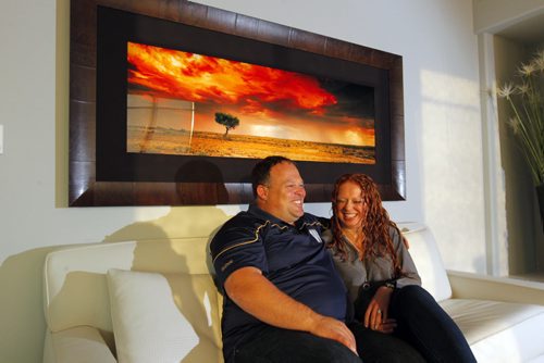 49.8 FEATURE - Wade Miller and his partner Melissa Malden collect art photography. Here they pose for a photo with one on the wall behind them.  BORIS MINKEVICH / WINNIPEG FREE PRESS  Sept. 24, 2014