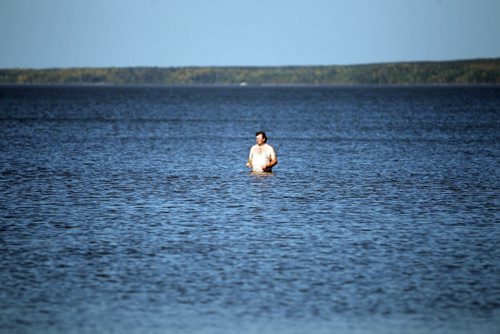 A man carefully wades in the frigid water at Grand Beach. NO ID ON MAN. A little bit of summer delivered to Manitobans in late September.  BORIS MINKEVICH / WINNIPEG FREE PRESS  Sept. 25, 2014