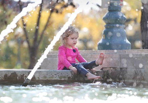 Two-year-old Sarah Clay dips her feet into the fountain on the  Legislative grounds to cool herself as her grandmother stands close by in the warm autumn weather Saturday afternoon.   Standup photo Sept 27,  2014 Ruth Bonneville / Winnipeg Free Press