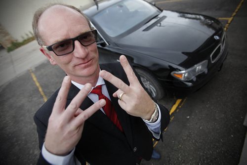 September 28, 2014 - 140928  -  Paul Edmond is photographed giving the EV hand sign for Electric Vehicle beside his gas guzzling BMW Sunday, September 28, 2014. Edmond wants to buy an electric car and wishes Manitoba Hydro would offer rebates and infrastructure. John Woods / Winnipeg Free Press