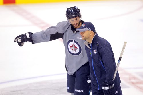 Jets practice at MTS Centre.  Jet's #14 ANTHONY PELUSO works with a coach on the ice. BORIS MINKEVICH / WINNIPEG FREE PRESS  Oct. 3, 2014