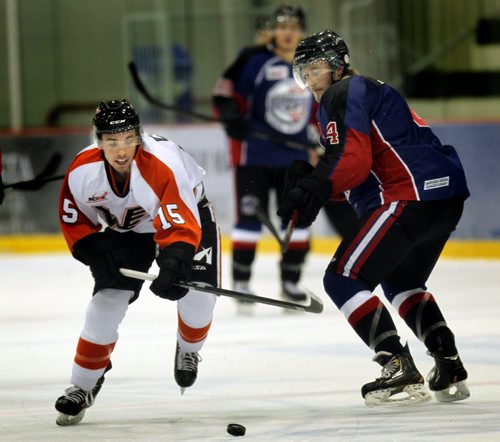 Winkler Flyer winger #15 Tristen Keck works hisway past  OCN Blizzard's defenceman # 4 Richard Gratz Friday afternoon at the IcePlex as the two teams met in the Old DUtch MJHL Showcase.  October 3, 2014 - (Phil Hossack / Winnipeg Free Press)
