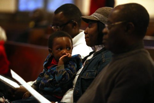 Edwin Neche, 14 mo, sitting with his mother, Liliosa, and father, Emanuel, left, at Knox United Church during a "Call for Prayer" for the Ebola crisis in West Africa, Friday, October 3, 2014. (TREVOR HAGAN/WINNIPEG FREE PRESS)