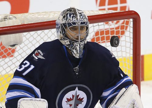 Winnipeg Jets' goaltender Ondrej Pavelec (31) stops the puck while playing against the Calgary Flames' during the first period of NHL hockey action in Winnipeg, Saturday, October 4, 2014. (TREVOR HAGAN/WINNIPEG FREE PRESS)