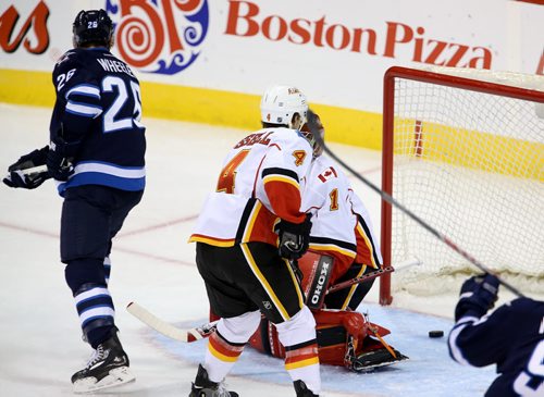 Winnipeg Jets' Blake Wheeler (26) deflects the puck past Calgary Flames' goaltender Jonas Hiller (1) to tie the game at 1, during the first period of NHL hockey action in Winnipeg, Saturday, October 4, 2014. (TREVOR HAGAN/WINNIPEG FREE PRESS)
